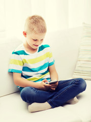smiling little boy with smartphone at home