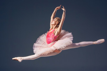 Beautiful female ballet dancer on a grey background. Ballerina