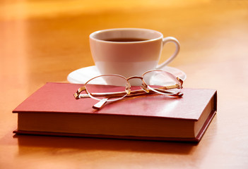 Fototapeta premium Book, glasses and tea on a wooden background