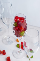 Sweet jellies in a champagne glass on a white table