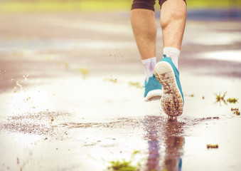 Young man running in rainy weather
