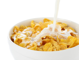 pouring milk into cornflakes bowl isolated on white