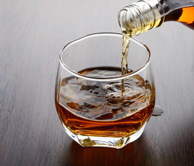 pouring whisky into glass - 76371849