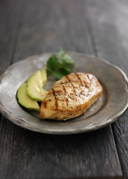grilled chicken with cilantro and avocado on metal plate