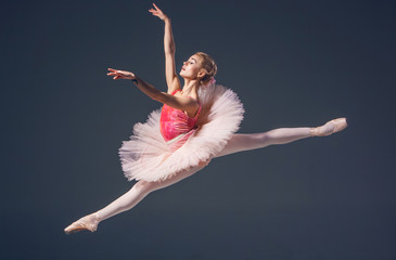 Beautiful female ballet dancer on a grey background. Ballerina