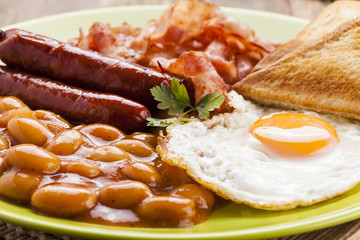 Full english breakfast with bacon, sausage, fried egg, baked bea