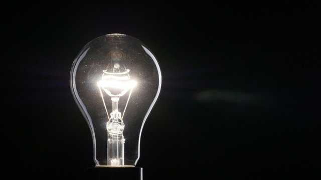 Light bulb over black background. 4K, UHD