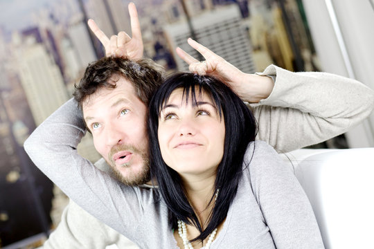 Funny couple making horns gesture one to another