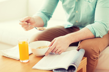 Fototapeta na wymiar close up of man with magazine eating breakfast