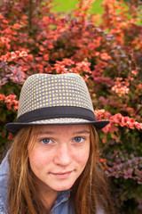 Young cute hipster girl close-up portrait in autumn garden.