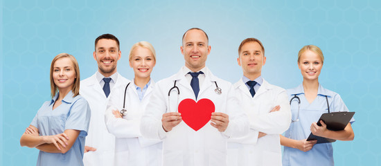 group of smiling doctors with red heart shape