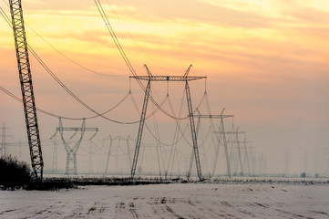 High-voltage power transmission towers in sunset