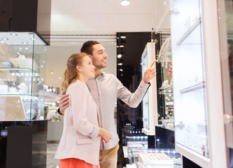 couple looking to shopping window at jewelry store