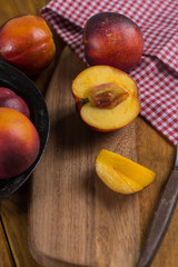 Organic fresh nectarine peach cut on rustic board