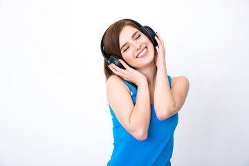 Naklejka premium Happy woman with headphones listening music with closed eyes