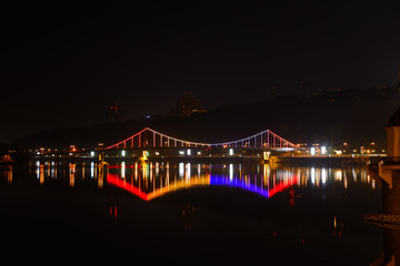 Fototapeta na wymiar Glowing colored lights bridge across the Dnieper River in Kiev