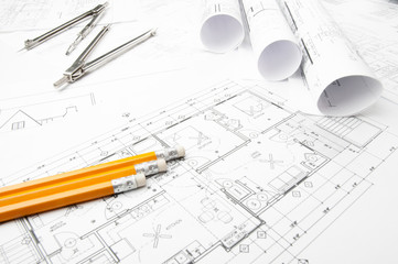 Construction blueprints on the worktable and drawing instrument