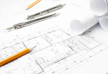 Construction blueprints on the worktable and drawing instrument