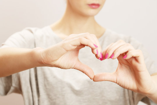 Young woman making heart symbol by her hands