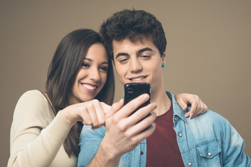 Cheerful young couple with mobile phone
