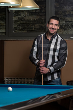Portrait Of A Young Male Model Playing Billiards