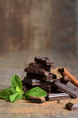 Stack of chocolate slices with mint leaf and cinnamon.