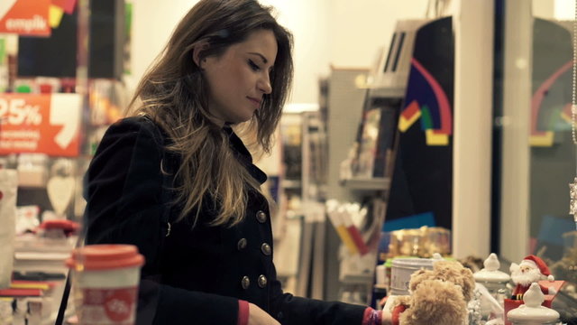 Young woman checking toys for christmas gift at shopping store 