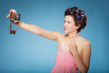girl in hair curlers taking picture with old camera