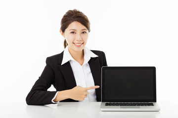 smiling young business woman  showing and pointing to the laptop