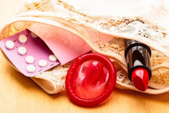 Pills condom and lipstick on lace lingerie