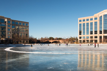 Ice skating rink on a frozen lake between office buildings