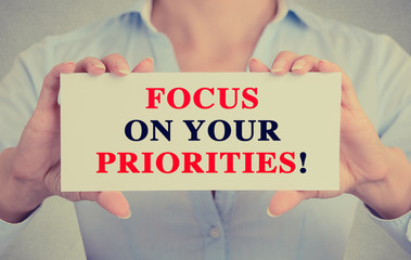 Businesswoman hands card focus on your priorities message