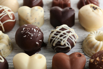 Delicious chocolate candies on wooden background