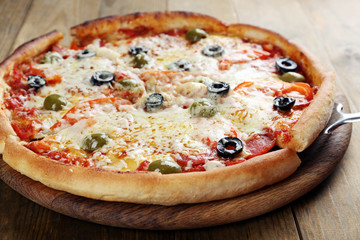 Pizza with cheese on board and wooden table background