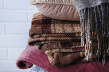 Warm plaids and pillow on white brick wall background