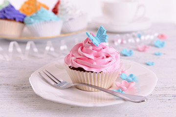 Delicious cupcakes on plate on table close-up