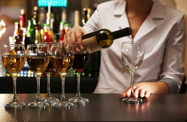 Bartender working at counter on bar background