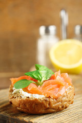 Canape with salmon and herbs on wooden background