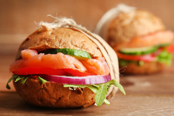 Sandwiches with salmon on wooden background