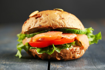 Sandwich with salmon on wooden background