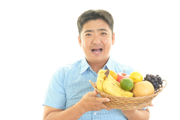果物を持つ笑顔の男性