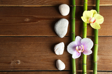 Orchid flowers  and bamboo with pile stones on wooden