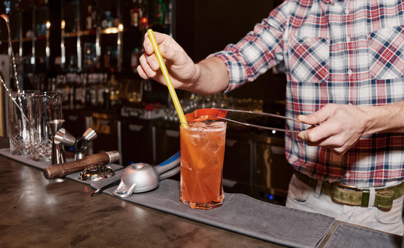 Bartender is decorating cocktail with bell pepper, toned
