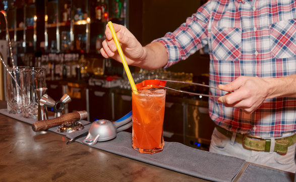 Bartender is decorating cocktail with bell pepper