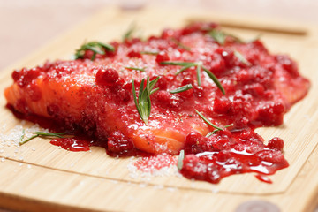 Salmon steak being marinated in salt with redberries