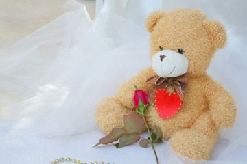 Teddy bear with red heart and red rose