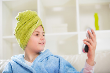 Teenager with towel on her head and mirror on her hands