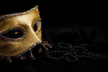 Golden mask and pearls on black