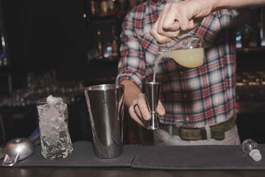 Bartender is making cocktail, toned image