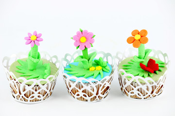 Fototapeta na wymiar sweet spring flowers muffin cakes on white
